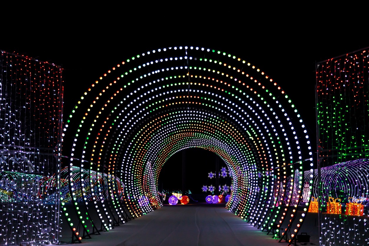 This image shows a vibrant, illuminated tunnel made of numerous colorful lights, creating a festive and mesmerizing atmosphere at nighttime.