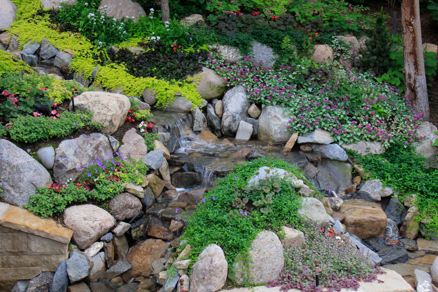 A garden with a stream and waterfall.